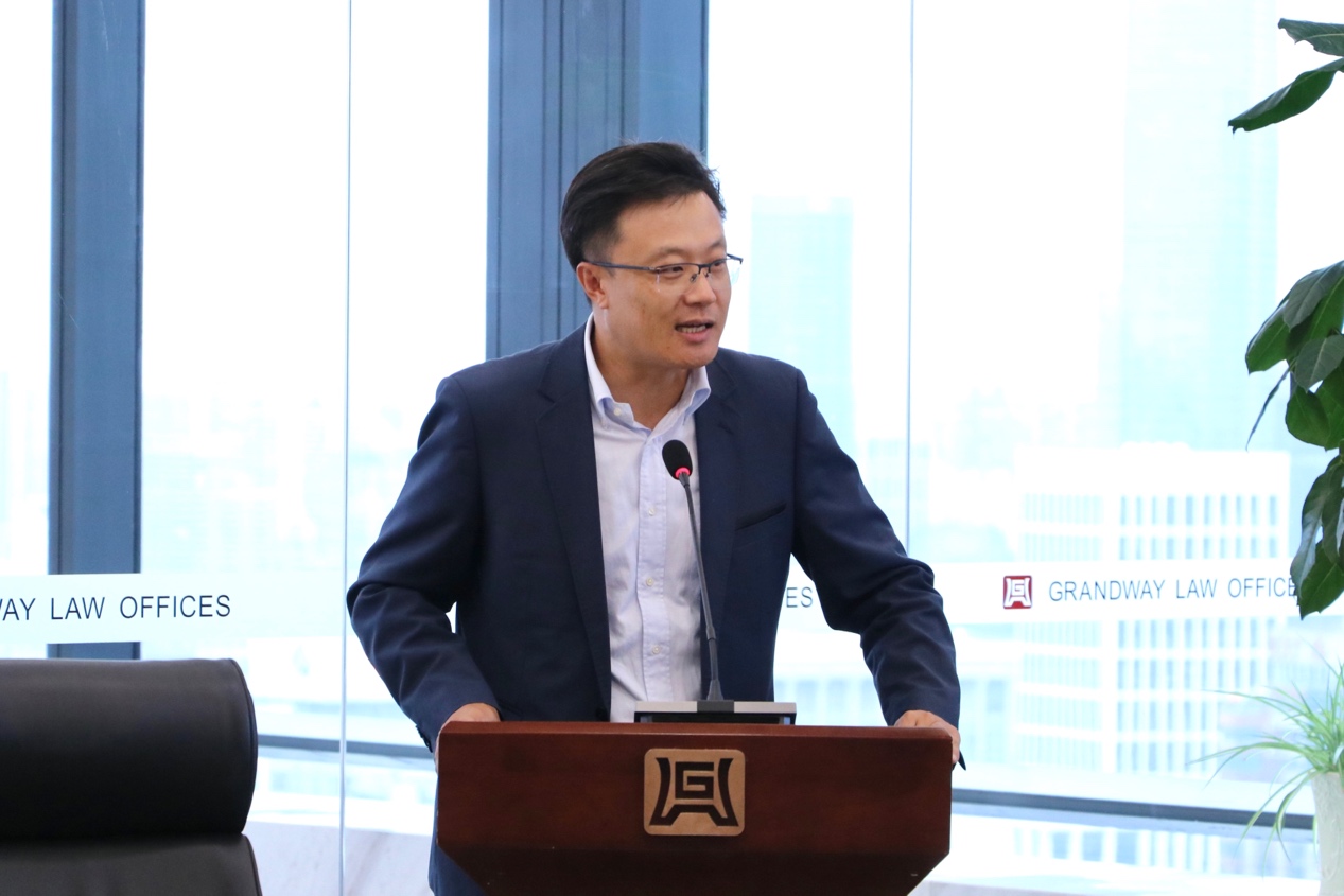 穿西装打领带的男人站在窗户边中度可信度描述已自动生成